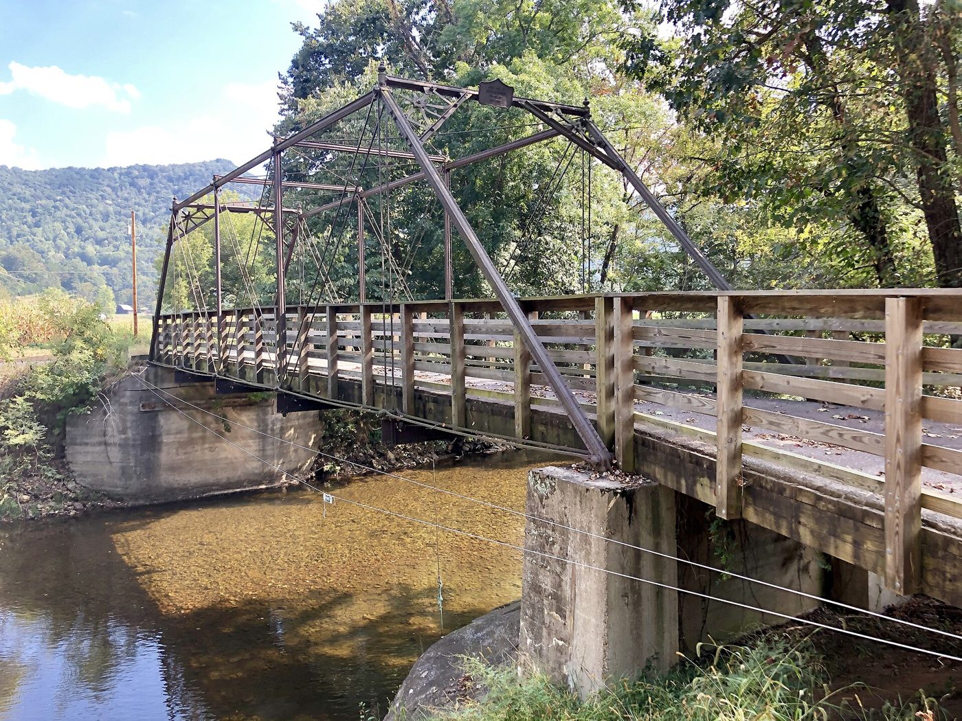 Iron Pratt truss bridge with slender rod diagonals and stockier compression members