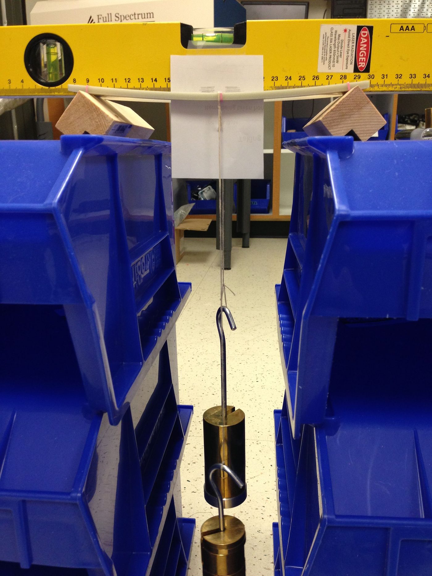 Three-point bending test: simply supported specimen with a central load visibly sagging